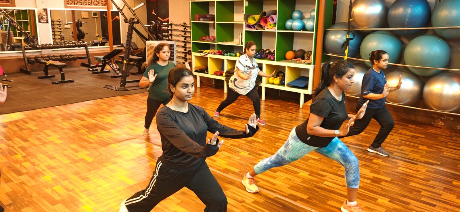 Women practicing controlled lunges in a group wellness session.